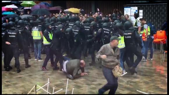 Man being thrown down by policemen in Barcelona during Catalonia vote.