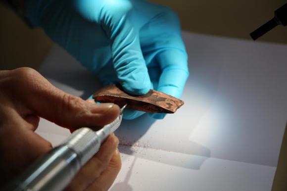examining an old copper axe-head