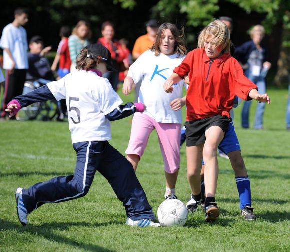quattro ragazze con handicap giocano a calcio.