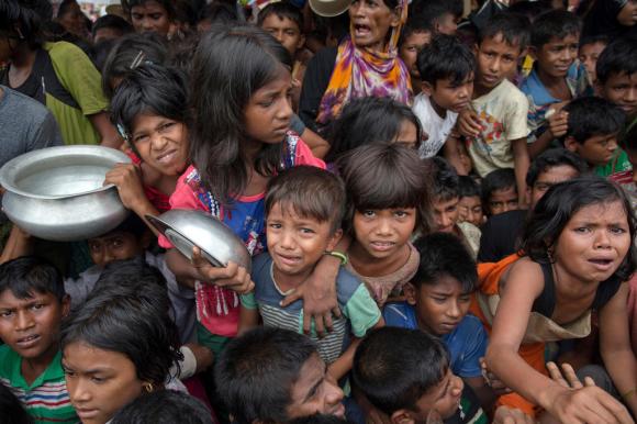 أطفال مُسلمي الروهينجا الذين عبروا الحدود إلى بنغلاديش من ميانمار ينتظرون تلقي العطاءات الغذائية