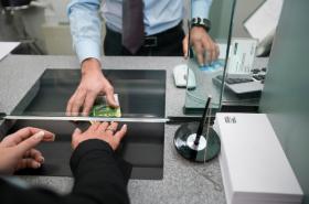 A bank cashier hands money over to a customer