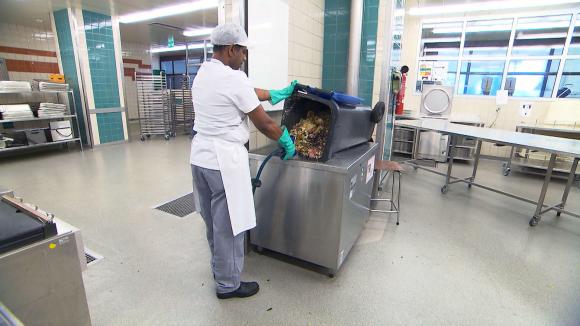 Man cleaning food waste bin