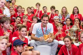 Roger Federer comiendo pizza con niños y niñas en Basilea.