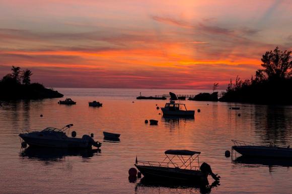 The sun sets behind moored boats at Sandy s Parish, Bermuda