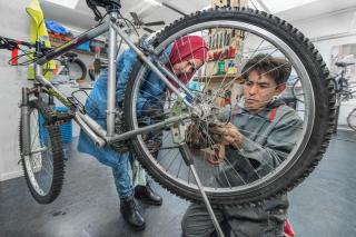 ワークショップで自転車を修理する男女