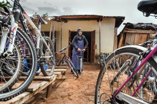 Jadida Nura infla la rueda de una bicicleta