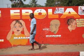 A Liberian man walks pass an Ebola awareness mural in downtown Monrovia, Liberia in 2015
