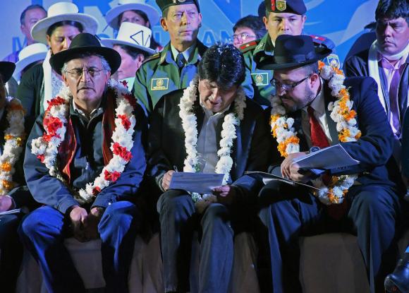 El presidente Morales rodeado de otros políticos con coronas de flores al cuello