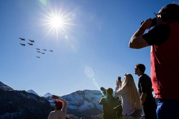 Un grupo de personas mira las acrobacias de la fuerza aérea suiza