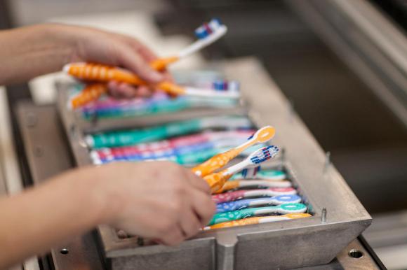 hands sorting toothbrushes