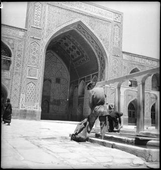 رجال يستكملون الوضوء قبالة مقام الإمام الرضا في مدينة مشهد، شرق إيران