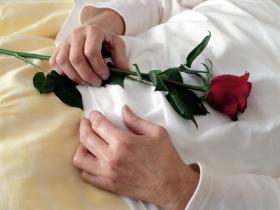 Una persona fallecida con una rosa roja en la mano