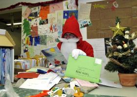 Papá Noel lee las cartas enviadas por los niños.