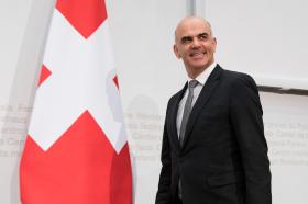 Alain Berset junto a la bandera de Suiza