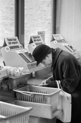 Una mujer frente a una caja registradora en los años 60