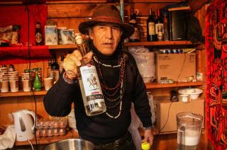 リキュールのボトルを見せるペルー人男性