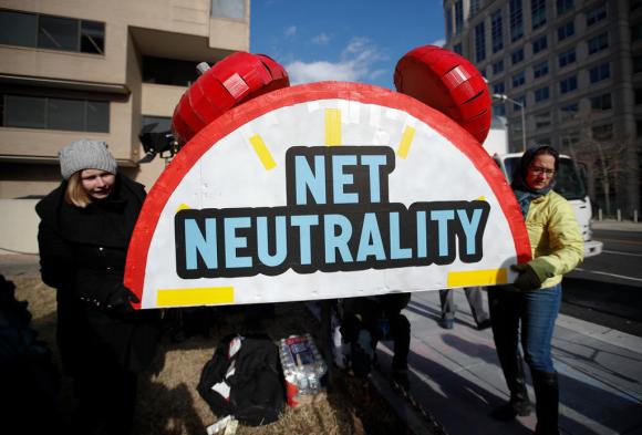 Protesters carry a net neutrality sign to the Federal Communications Commission headquarters in Washington, DC