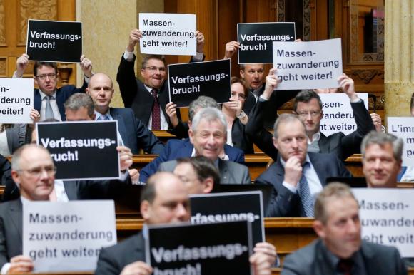 Members of the Swiss People s Party in the House of Representatives holding signs
