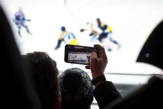 Stadionbesucher filmt mit dem Mobiltelefon das Spiel