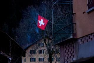 Una bandera suiza flota desde una casa.