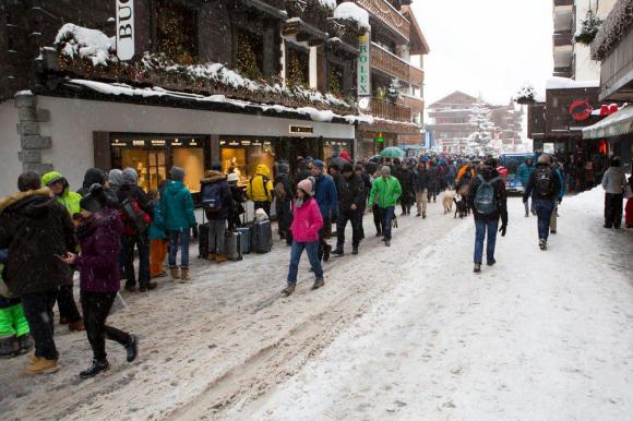 People stand in line to buy a ticket for a flight with a helicopter of Air Zermatt