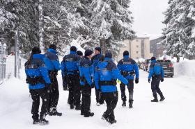 blue-clad police on snow-covered road