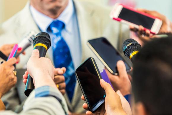 Micros et téléphones tendus pour une interview.