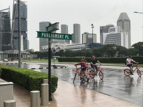 シンガポールの大通り。高層ビルと自転車に乗った子供たち