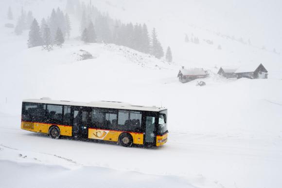 Gelbes Schweizer Postauto im Schnee