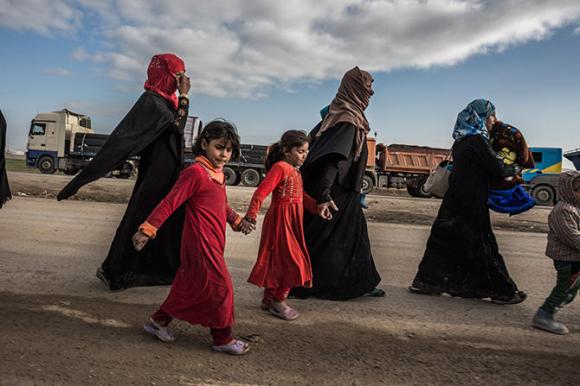 Tres mujeres con sus hijos escapan a tiroteo en Mosul, Irak.