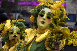 Personajes de carnaval reparten flores en Basilea