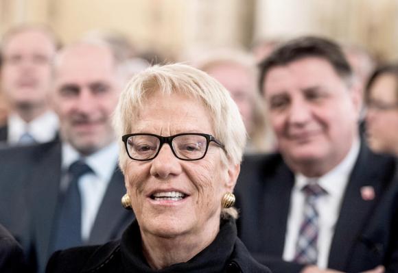 Face of Carla Del Ponte, 71, with short blonde hair and glasses, smiling