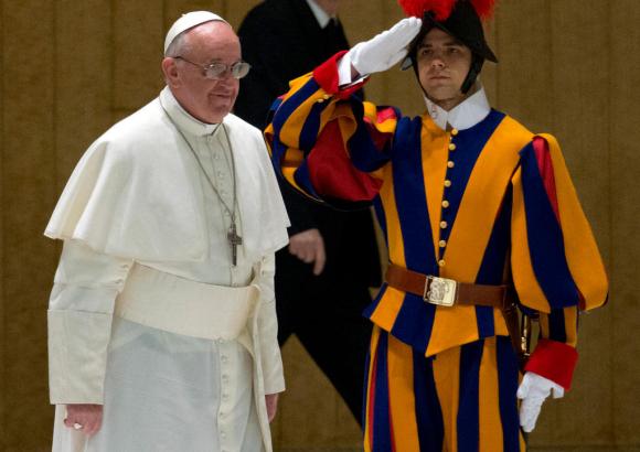 El Papa Francisco habla con un guardia suizo en 2013.