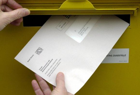 Pair of hands posting an envelope with vote papers
