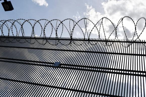 Sbarre e filo spinato attorno a un carcere.