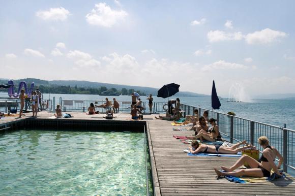 People sunbathing at a lido in Zurich by the lakeshore