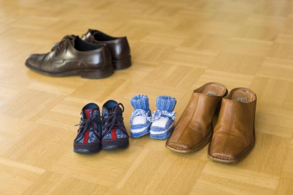 Sapatos de criança ao lado de sapatos de homem