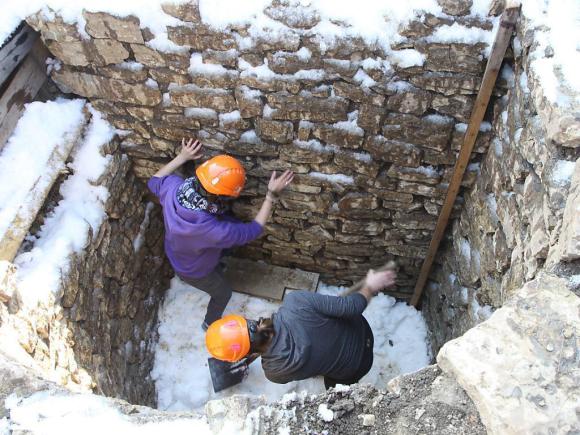 Archaeologists packing snow in a hole