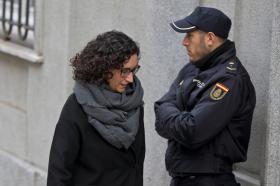 Marta Rovira pasa delante de un miembro de las fuerzas del orden
