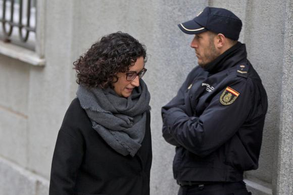 Marta Rovira pasa delante de un miembro de las fuerzas del orden