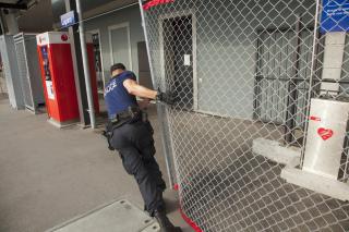 ルガーノ駅で安全網を閉める警官