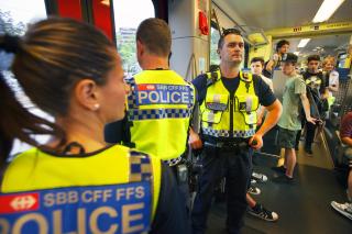 Drei Polizisten und Jugendliche im Zug