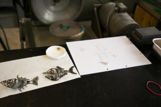 Sketch paper and metal fish-like objects.