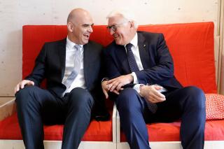 El presidente suizo Alain Berset (izq.) y su homólogo alemán Frank-Walter Steinmeie sentados en un sofá.