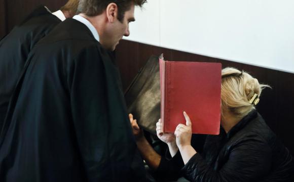 Mulher em um tribunal escondendo o rosto