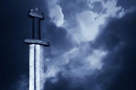 Epée de Damoclès sur fond de nuages sombres.