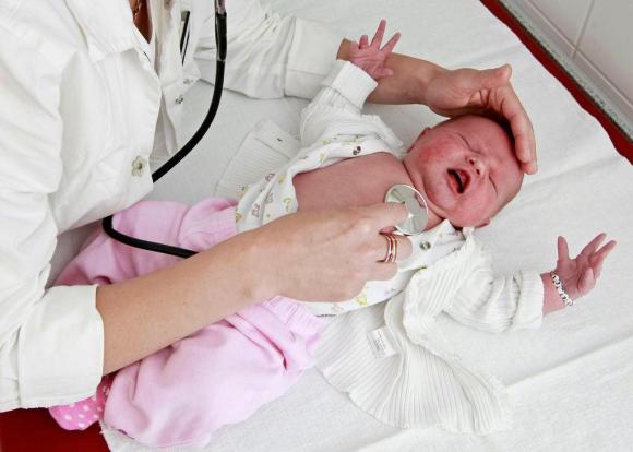 Médico examina um bebê de dois dias de idade