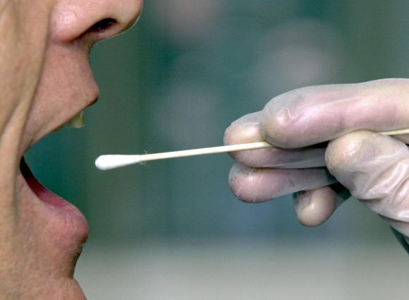 Una persona con la boca abierta para la toma de pruebas de saliva