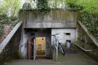 Entrance to a bunker, a bike stands leaning to a metal rail