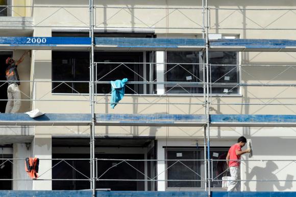 Arbeiter auf einem Gerüst an einem Neubau.